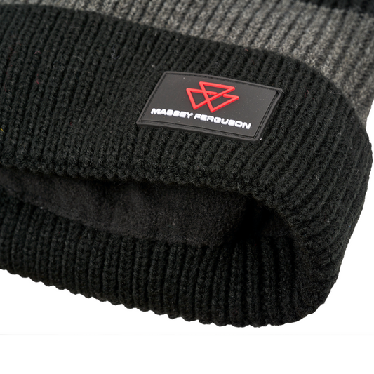 Close-up of the AGCO Massey Ferguson knitted beanie (X993482302000), featuring a black and grey woolen design with an embroidered red logo and "Massey Ferguson" text on a black patch.