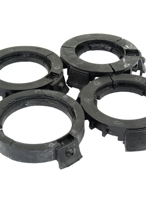 Four black plastic washer guides with grooves, distinctly arranged in a cluster on a white background, provide an efficient solution akin to Sparex PAK-PTO Bearings Eco-Small (Sparex Part No. S.10470).