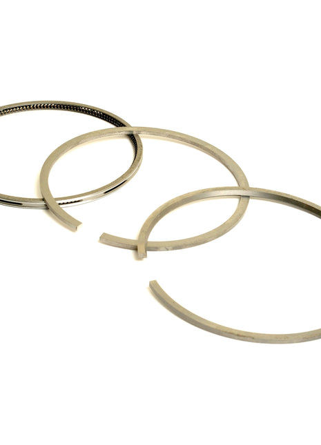 Three metal piston rings of varying diameters, arranged in a triangular layout on a white background, symbolize the precision engineering found in the Sparex Piston Ring | Sparex Part No.S.110974.