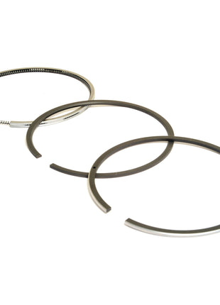 Three metal piston rings, with one fully intact and two open-ended, arranged side by side against a white background. These components include the Sparex Piston Ring (Sparex Part No. S.110975), commonly used in Case IH Models and Sisu Engines.