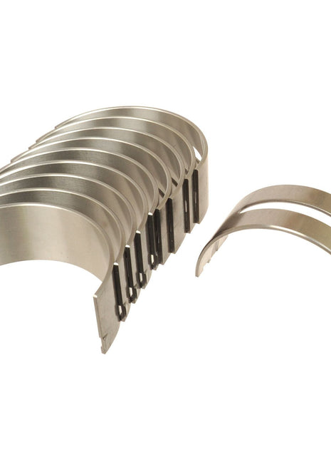 A set of eight metallic curved engine bearing shells, featuring one shell separated from the group, ideal for Sparex Perkins or Massey Ferguson machinery. This product is known as the Main Bearing +0.020'' (0.50mm) (Set), Sparex Part No.S.111797 by Sparex.