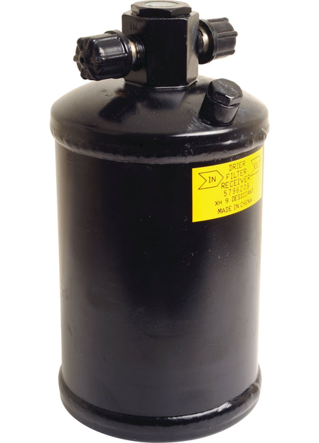 The Sparex Filter Drier - S.111929 is a black cylindrical filter receiver featuring two valve knobs and a yellow label, and it is compatible with Ford New Holland systems.