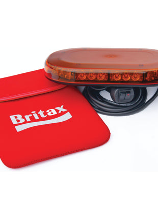 The LED Micro Hazard Light with amber LEDs, a black cable, and a red power switch features magnetic fixing for easy attachment. It comes next to a red zippered carrying case labeled "Britax." The product, identified as S.28672 by Sparex, operates on 12-24V and has a single flash function.