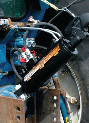 Close-up of a Sparex Hydraulic Top Link (Cat.36mm/3) Knuckle and Q.R CBM Hook, with its robust 90mm hydraulic cylinder bore, attached to the back of a blue tractor. Visible are the intricate hydraulic hoses and control valve, while the tractor tire and part of this efficient tractor implement are also in view. The product has a minimum length of 650mm and is identified by Sparex Part No. S.331204.