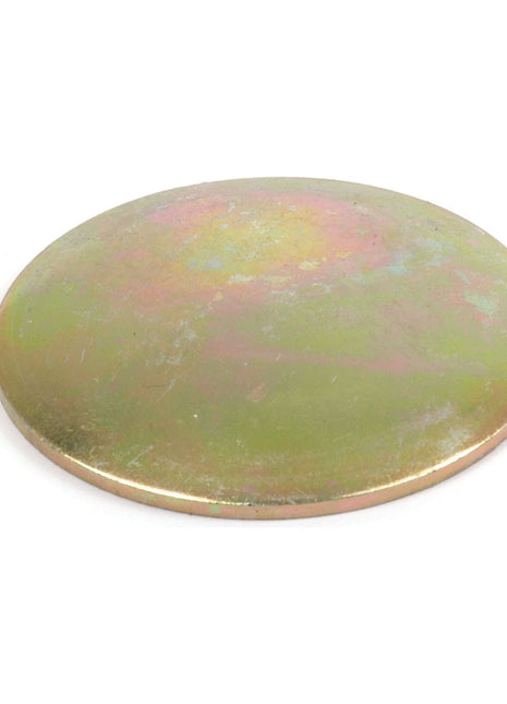 A round, flat metal disk with a slightly tarnished surface, displaying a mix of gold and green hues; it appears to be the Core Plug - 1 3/4'' (Dished Type - Mild Steel) from Sparex, commonly used in Ford/New Holland machinery.