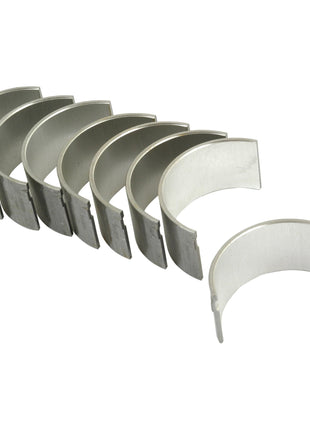 A set of seven curved metal bearing shells, identified as the Conrod Bearing +0.030'' (0.75mm) Set by Sparex (Part No. S.40322), compatible with Massey Ferguson 165 and Landini 6000 tractors, arranged in a line on a white background.