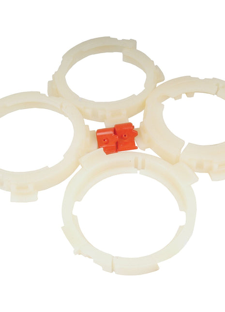 Four white plastic rings are arranged in a diamond shape around a small red connector piece, resembling the EASYLOCK BEARING PACK - X-LAR by Sparex (Sparex Part No. S.20538).