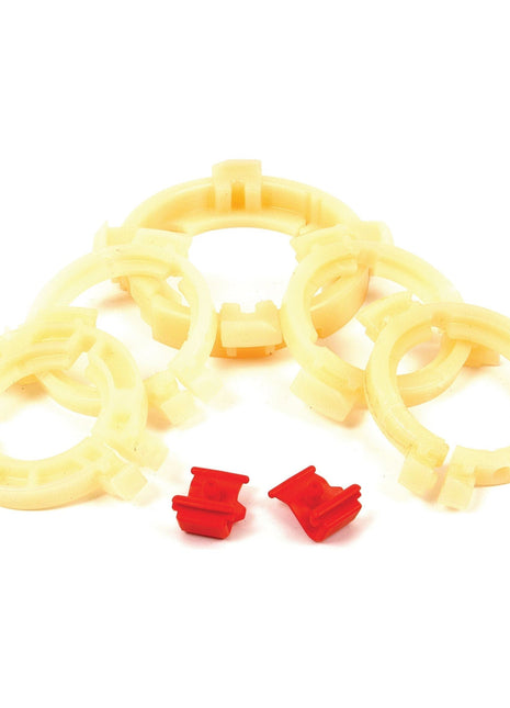 Five beige plastic rings arranged in a semi-circle with two small Easylock Bearing Pack (Sparex Part No. S.20536) Medium clips in red placed in front of them.