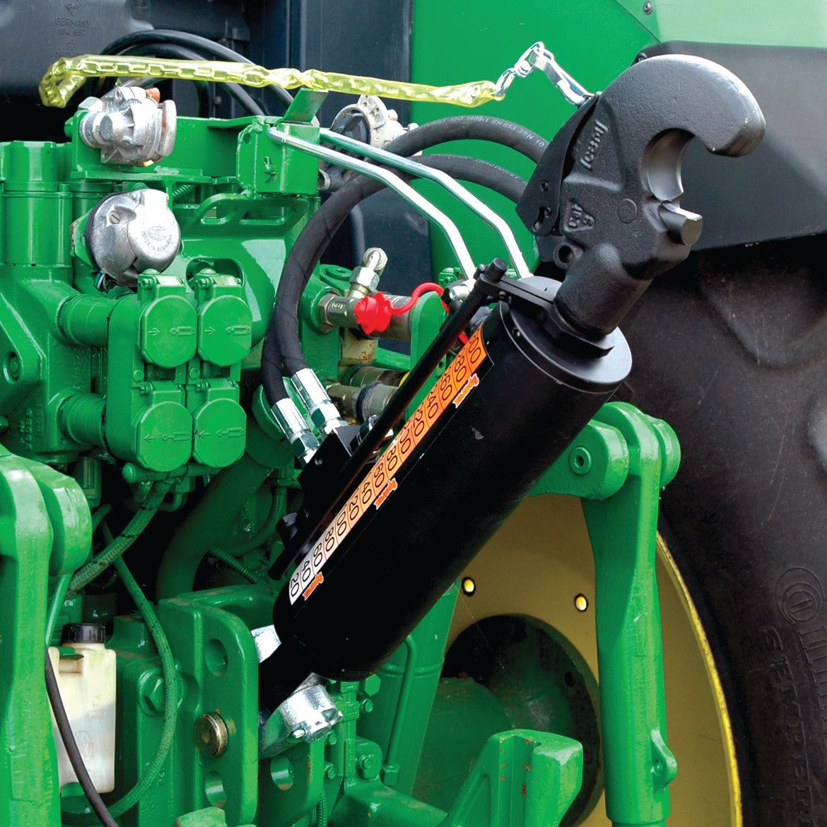 Close-up view of a green agricultural machine with hydraulic components, featuring the prominent Sparex Hydraulic Top Link (Cat.2/3) Knuckle and Q.R CBM Hook, with a 90mm cylinder bore and minimum length of 690mm, along with a black hydraulic cylinder attached to the machinery and complete with a Category 2/3 hose set.