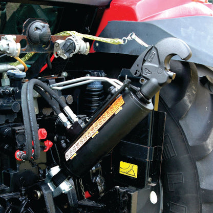 Close-up of a Sparex Hydraulic Top Link (Cat.2/3) Knuckle and Q.R CBM Hook, with a 90mm cylinder bore and minimum length of 690mm, attached to the rear of a red tractor.