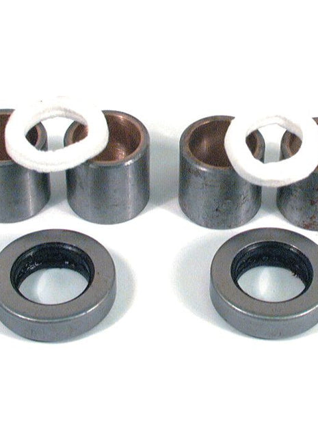 Two pairs of cylindrical metal components with white bushings, along with two circular black and silver rings, all arranged on a white surface. This set belongs to the Spindle Repair Kit from Sparex (Part No. S.42040) for Massey Ferguson, ensuring durable and efficient maintenance.