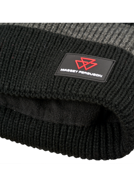 Close-up of the AGCO Massey Ferguson knitted beanie (X993482302000), featuring a black and grey woolen design with an embroidered red logo and "Massey Ferguson" text on a black patch.