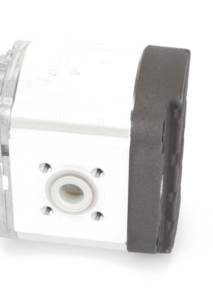 Close-up of the AGCO Hydraulic Toothed Wheel Pump - F716100490110, featuring a rectangular shape with a metallic body, black and white sections, and a central circular opening on one side. Unfortunately, no current product description information is available for this item.