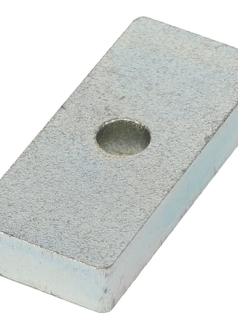 The AGCO | Spacer - Acw0593330, crafted by AGCO, is a rectangular metallic block featuring a subtle circular indentation at its center, embodying simplicity and precision.
