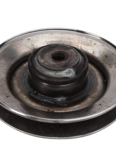 An AGCO | PULLEY - D28485390, a weathered, metallic pulley with a central hole and surrounding grooves, showing clear signs of wear and corrosion.