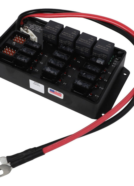 Image of the AGCO POWER DISTRIBUTION MODULE - AG124451, an automotive fuse box with multiple slots for fuses and relays, connected to red and black electrical wires with ring terminals.