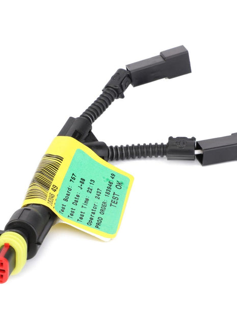 Close-up of a black automotive wiring harness with two connectors, one labeled "TR60-B," and a yellow tag with part information attached. For machinery safety and reliability, this genuine AGCO Parts electric component, specifically the Harness, Fuel Tank - 4293508M1, is essential for Massey Ferguson models.