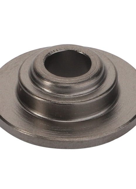 The AGCO | Washer - Acp0676180, offered by AGCO, features a raised central cylinder and several intricately carved concentric grooves.