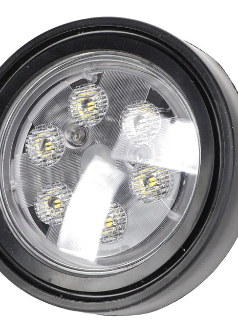 The AGCO | LAMP - ACP0401710 features a round LED light with a black casing and six visible LED bulbs inside. It boasts a clear lens and has a small section of attached wiring on the side. For any ordering inquiries or assistance, please contact our support team.