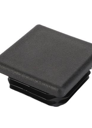 The AGCO Plug - Acw9221570 is a black rectangular plastic end cap with a textured surface and ridged edges, meticulously designed to fit into hollow tubing or open-ended structures.