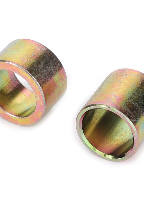 Two cylindrical metal sleeves with a brass-like finish, identified as AGCO | Spacer - 4279937M1 by the brand AGCO, are displayed side by side on a white background. No current product description available.