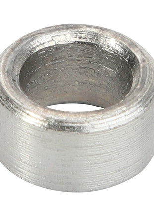A close-up view of the AGCO | SPACER - AL60011340, a metallic cylindrical spacer with a hollow center and textured surface. No current product description information is available.
