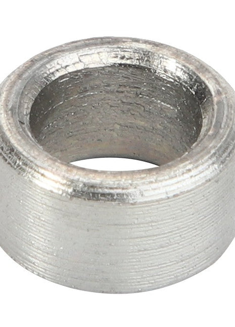 A close-up view of the AGCO | SPACER - AL60011340, a metallic cylindrical spacer with a hollow center and textured surface. No current product description information is available.