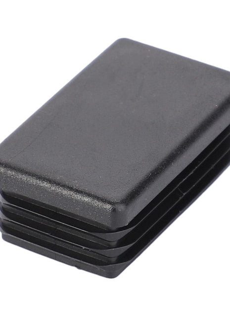 The AGCO | PLUG - V30320600 is a rectangular black plastic end cap featuring ridges on one end. No additional product description information is available at this time.
