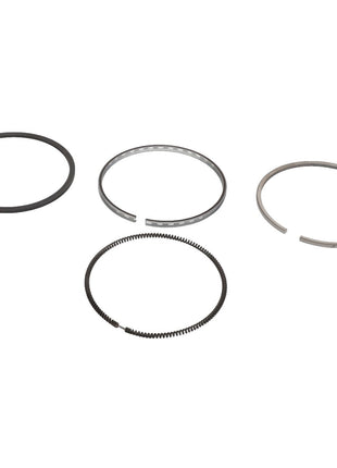 Four AGCO metal piston rings from the KIT, RING - 0.008.0052.6 are arranged in a horizontal line, each varying slightly in thickness and design. For any questions or assistance with ordering, please contact our support team. The background is white.