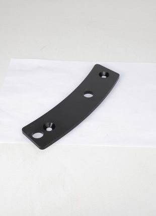 An AGCO Spacer, Right Hand - 4389261M1, a black curved metal bracket with three holes and currently without a product description, is placed on a white surface.