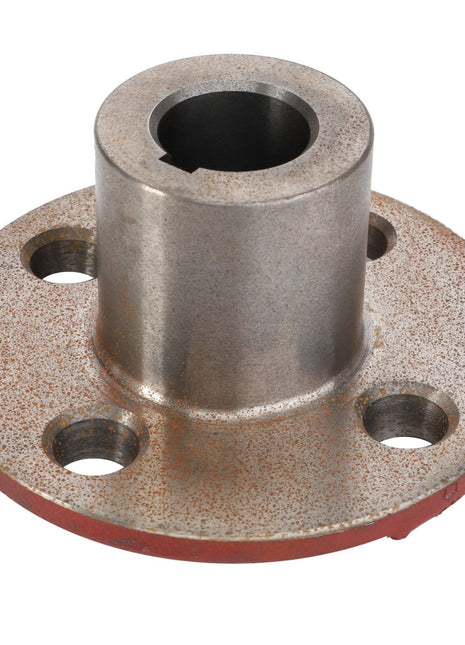 The AGCO Hub - La300131755 is a metal flange with a cylindrical extension and four holes around the base. It shows light rust and has a red coating on the underside. Currently, there is no additional product description available.