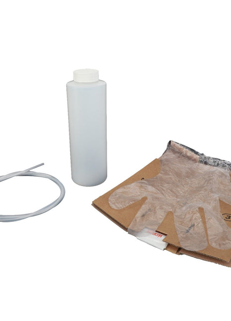 A clear plastic bottle with a white cap, a plastic glove on a cardboard base, and a coiled flexible tube are displayed on a plain white background. The product is described as the AGCO | Test Unit - Acp0662270 by the brand AGCO.