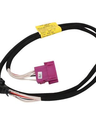 The AGCO Harness - Acw138345A is a black cable assembly featuring a purple rectangular connector on one end and a black rectangular connector on the other. A yellow label with text is attached to the cable, detailing crucial specifications and safety information.