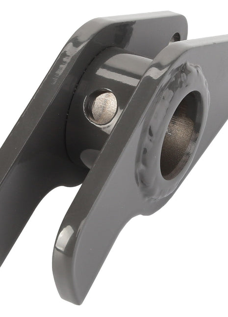 Close-up of the AGCO Lever - Fel15290209, a gray metallic hinge bracket featuring two mounting holes and a central cylindrical opening. This AGCO branded bracket boasts a compact and robust design, making it ideal for mechanical or structural applications. Detailed product specifications are currently unavailable, emphasizing the necessity for comprehensive information.