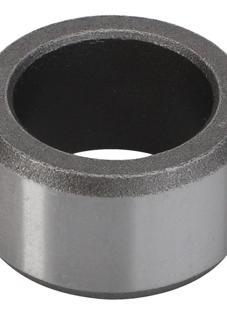 A close-up of the AGCO Bush - F334300020090, a cylindrical, metallic ring object with a smooth outer surface and a dark inner core.