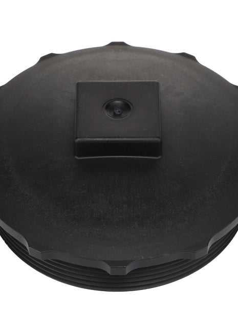 Close-up view of the AGCO Cap Fitting - Acw2407700 featuring a black plastic lid with a square knob in the center. No current product description information available.