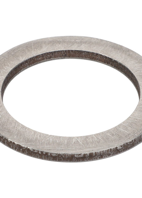 The AGCO Adjusting Washer - Acp0500000 is a metal washer with a smooth surface, featuring a large central hole and a slightly rough outer edge.