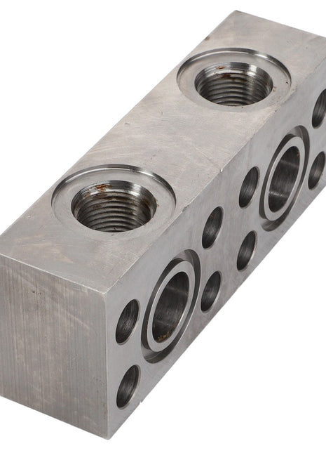 AGCO | ADAPTER - D28187335 is a rectangular metal hydraulic manifold block featuring cylindrical openings, multiple ports, and threaded connections to facilitate the flow and distribution of hydraulic fluid. Brand Name: AGCO. No current product description information is available.