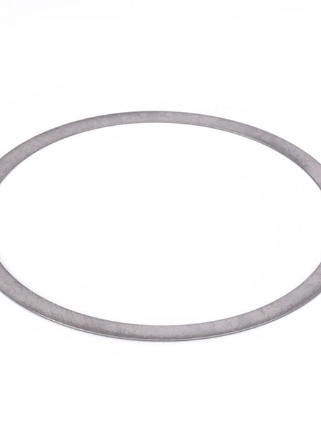 The AGCO Shim - F411301021100, a thin, flat, circular metal washer with a smooth surface, gleams gently against a pristine white background.