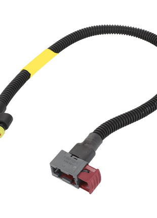 The AGCO | Harness - Acw385963A, available in black, features a coiled protective covering. It includes red and gray connectors at each end and a yellow label near the top. Please note that no current product description information is available.