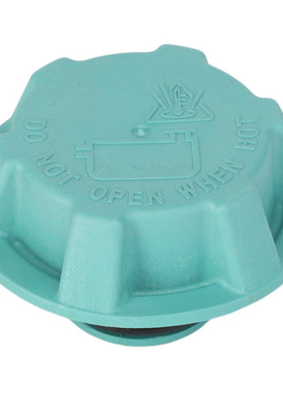 Close-up of the AGCO | Tank Cap - F530200050600, depicting its green color and featuring the warning "DO NOT OPEN WHEN HOT" alongside a symbol of a hand near steam on its surface.