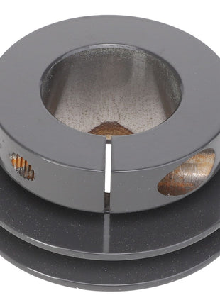 A close-up view of the AGCO Sheave - Acx2766610, a black cylindrical metal object with a hollow center and circular cutouts on the sides.