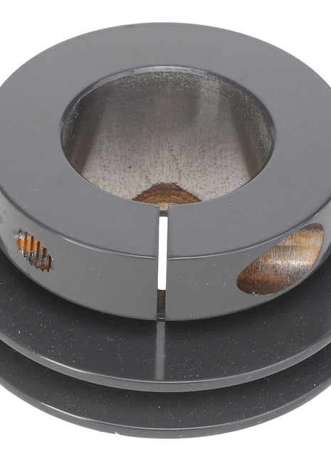 A close-up view of the AGCO Sheave - Acx2766610, a black cylindrical metal object with a hollow center and circular cutouts on the sides.