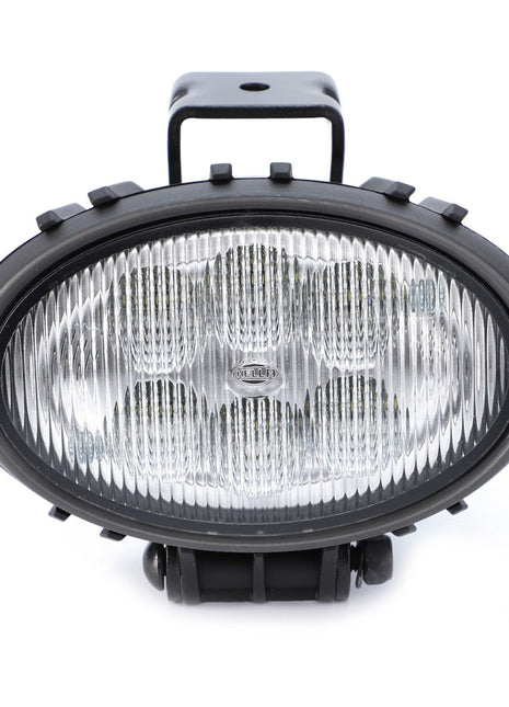 The AGCO Work Light, Led - Acw2237910 from AGCO features an oval shape with a ribbed, transparent lens and a rugged black casing, offering enhanced durability and front-facing capability. This AGCO Genuine LED Work Light ensures reliable performance in all conditions.