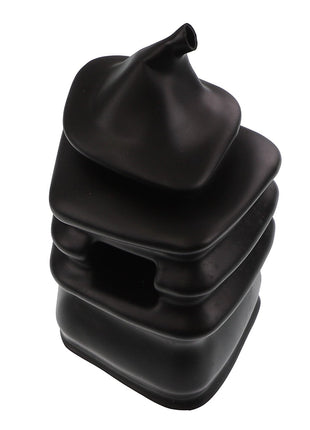 A stack of black, squarish, soft-looking shapes with a pointed top, resembling a sculptural object or a unique container. This is the AGCO GAITER - AL60006255 by AGCO. No current product description information is available.