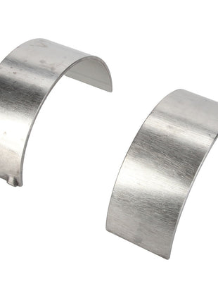 Two curved, metallic AGCO | Bush - Acp0309640 bearings with smooth surfaces placed side by side on a white background.