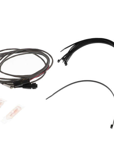 A collection of AGCO cables and wires (model AG610624) with connectors, alongside two small packets containing clear liquid.