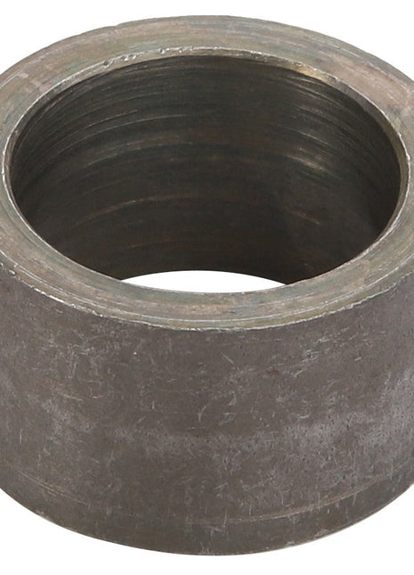 The AGCO SPACER - D28782757 is a cylindrical metal ring-shaped component with a rough, slightly tarnished surface. The interior is threaded, indicating it serves a mechanical purpose. Detailed product description information for this AGCO item is currently unavailable.