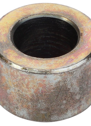 The AGCO Spacer Tube - Fel140180, a cylindrical metal object with a central hole, features a weathered or corroded surface. No current product description is available.
