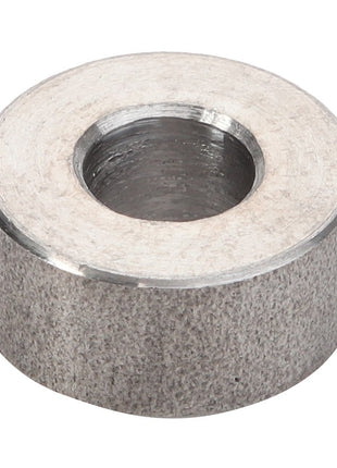 The AGCO Spacer Piece - V836119067, with its cylindrical shape and brushed finish, gleams under the light.